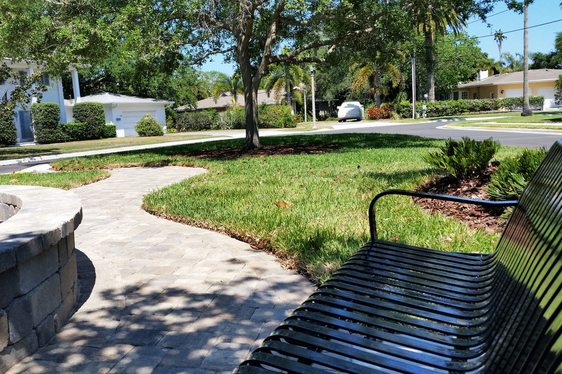 A black bench in Fountain Square Park with the rest of the park in the background