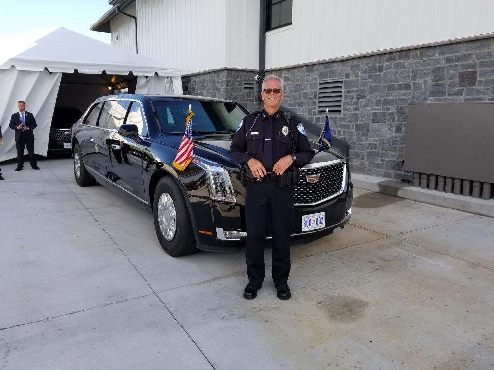 Officer Bowers poses next to a presidential limo