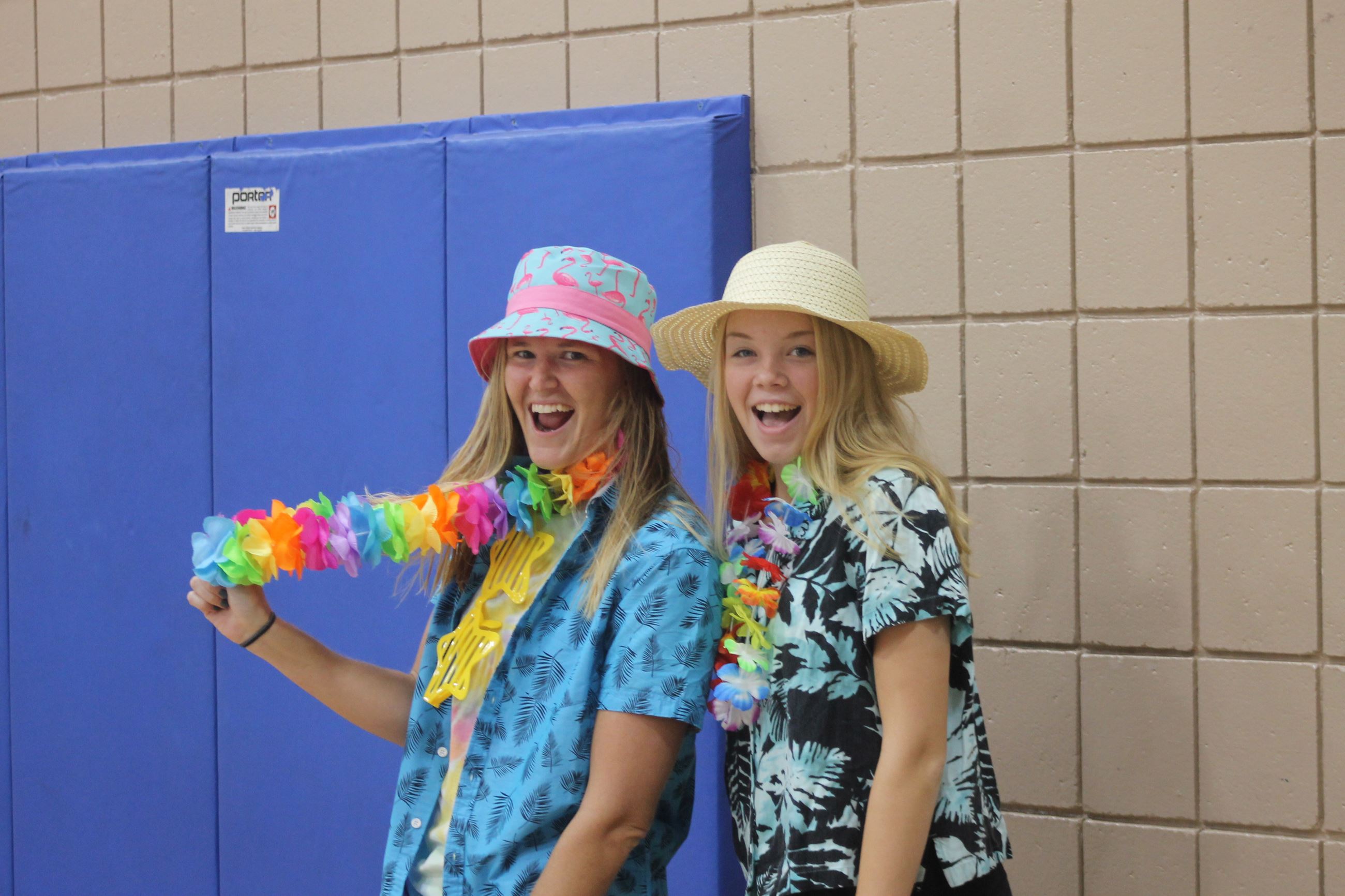Two recreation employees wear tacky tourist gear at a themed day at summer camp