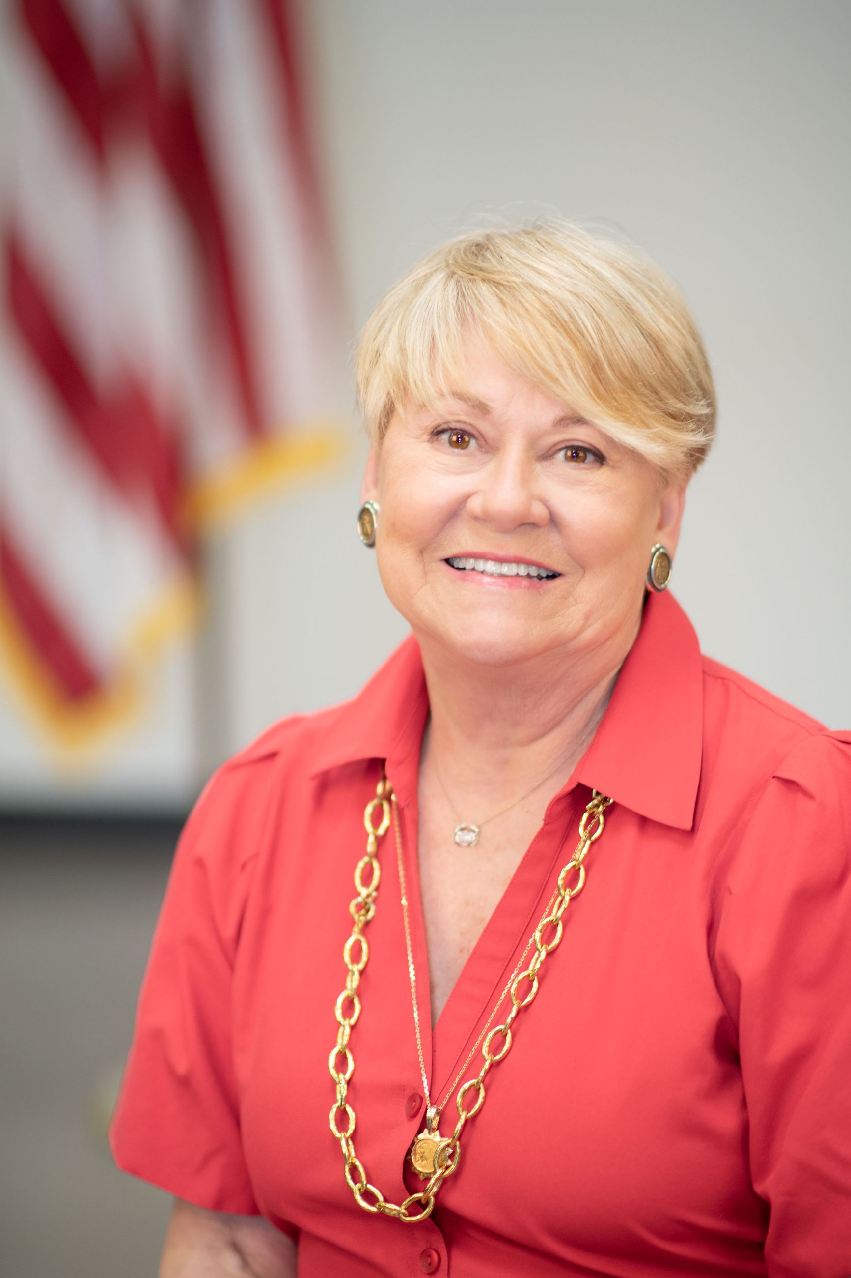 Town Manager Gay Lancaster poses smiling in front of the American flag.
